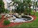 Scenic water feature with rocks and waterfall, surrounded by lush landscaping and colorful mulch at 4240 Ironwood Cir # 302A, Bradenton, FL 34209