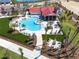 Aerial view of a resort-style pool and clubhouse with ample seating and manicured lawns at 44234 Creekside Run Ln, Punta Gorda, FL 33982