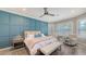 This bedroom features a stylish accent wall, ceiling fan, and large windows allowing for ample natural light at 4717 Zeno Ct, Bradenton, FL 34211