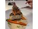 Close up of a white plate that is topped with fish, carrots, sprouts and a cream sauce at 4717 Zeno Ct, Bradenton, FL 34211