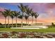 Signage with the community name, Esplanade, and palm trees near a well-maintained lawn with flowers under a colorful sky at 4717 Zeno Ct, Bradenton, FL 34211