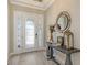 Bright foyer featuring wood flooring, a decorative front door, a console table, and a round mirror at 4717 Zeno Ct, Bradenton, FL 34211