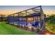 An enclosed pool next to a lush green lawn, with outdoor furniture for lounging and relaxation in a tranquil setting at 4717 Zeno Ct, Bradenton, FL 34211