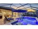 This screened-in pool area features a patio, spa, and backyard views at 4717 Zeno Ct, Bradenton, FL 34211