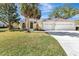 Charming single-story home with a three-car garage, lush green lawn, and mature landscaping at 4724 White Tail Ln, Sarasota, FL 34238