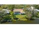 An aerial view displays the home's large tiled roof, screened-in pool, and lush greenery at 4745 Antler Trl Trl, Sarasota, FL 34238