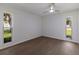 This bedroom features light wood floors, white walls and two windows to let in light and views at 5011 Live Oak Cir # 65, Bradenton, FL 34207