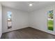 This bedroom features light wood floors, white walls and two windows to let in light and views at 5011 Live Oak Cir # 65, Bradenton, FL 34207