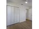 This bedroom features light wood floors, an open doorway, and a closet with shutter doors at 5011 Live Oak Cir # 65, Bradenton, FL 34207