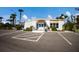 Exterior view of a community building with parking, lush landscaping, and a sidewalk entrance at 5011 Live Oak Cir # 65, Bradenton, FL 34207