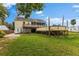 Backyard showing an elevated deck, ample green space, and a two-story home in the background at 503 1St Nw Ave, Ruskin, FL 33570