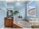 Beautiful bathroom featuring a granite vanity top, modern lighting, and a soaking tub at 503 1St Nw Ave, Ruskin, FL 33570