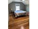 Bedroom featuring hardwood floors, a window with blinds, and a decorative comforter at 503 1St Nw Ave, Ruskin, FL 33570