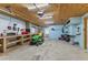 Spacious garage interior featuring work benches, tools, and a riding lawn mower at 503 1St Nw Ave, Ruskin, FL 33570