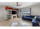 Stylish living room featuring a fireplace, shelving, a blue sectional, and bright natural light at 503 1St Nw Ave, Ruskin, FL 33570