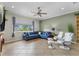 Bright living room featuring a blue sectional sofa and two modern white chairs with natural light at 503 1St Nw Ave, Ruskin, FL 33570