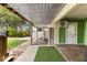 A covered patio with a wooden deck, an AC unit, and a path to a green backyard at 503 1St Nw Ave, Ruskin, FL 33570