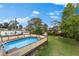 Above ground pool with deck in a backyard with green grass, some trees, and houses in the background at 503 1St Nw Ave, Ruskin, FL 33570