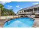 Backyard view with a partially above-ground pool and a two-story home in the background at 503 1St Nw Ave, Ruskin, FL 33570