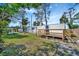 Spacious backyard featuring a wooden deck, privacy fence, shed, and lush grass under a partly cloudy sky at 5061 Placida Rd # A, Englewood, FL 34224