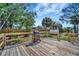 Spacious wooden deck, with grill, surrounded by a natural wood fence and lush greenery under a bright sky at 5061 Placida Rd # A, Englewood, FL 34224