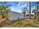 Exterior view of home showcasing white siding, blue shutters, mature trees, and well-maintained lawn at 5061 Placida Rd # A, Englewood, FL 34224