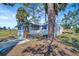 Charming home with a screened porch, adjacent deck, blue trim, and a well-maintained lawn with mature shade trees at 5061 Placida Rd # A, Englewood, FL 34224
