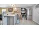 Well-equipped kitchen with stainless steel appliances, gray cabinets, and breakfast bar seating at 5061 Placida Rd # A, Englewood, FL 34224