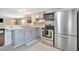 Modern kitchen featuring gray cabinets, stainless steel appliances, and stylish backsplash at 5061 Placida Rd # A, Englewood, FL 34224