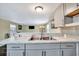 Close-up of kitchen with gray cabinets, marble countertops, and stainless steel sink with modern fixtures at 5061 Placida Rd # A, Englewood, FL 34224