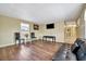 Open living room with wood floors, two chairs, mounted television, and a dark colored leather couch at 5061 Placida Rd # A, Englewood, FL 34224
