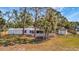 Mobile home with a storage building and wood fencing amongst mature trees at 5061 Placida Rd # A, Englewood, FL 34224