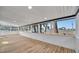 Enclosed sunroom with wood floors and a wall of windows showcasing the surrounding greenery and neighborhood views at 5061 Placida Rd # A, Englewood, FL 34224