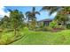 Well-manicured backyard showcases vibrant green lawn, diverse plantings, and a charming patio area at 5068 Inshore Landing Dr, Apollo Beach, FL 33572
