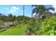 Spacious backyard with lush landscaping, mature trees, and an inviting green lawn at 5068 Inshore Landing Dr, Apollo Beach, FL 33572