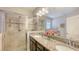 Granite double sink bathroom with glass enclosed shower and lots of vanity lighting at 5068 Inshore Landing Dr, Apollo Beach, FL 33572