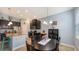 A dining area features a black table and chairs, complemented by natural light from nearby windows and dark wood cabinets at 5068 Inshore Landing Dr, Apollo Beach, FL 33572