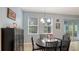 A dining area features a black table and chairs, complemented by natural light from nearby windows and patio doors at 5068 Inshore Landing Dr, Apollo Beach, FL 33572