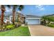 Charming single-story home with a well-manicured lawn, featuring a two-car garage and colorful landscaping at 5068 Inshore Landing Dr, Apollo Beach, FL 33572