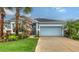 Charming single-story home with a well-manicured lawn, featuring a two-car garage and colorful landscaping at 5068 Inshore Landing Dr, Apollo Beach, FL 33572