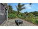 Covered tiled patio surrounded by a lush garden with tropical plants, creating a serene and private retreat at 5068 Inshore Landing Dr, Apollo Beach, FL 33572