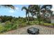 Landscaped backyard with a tiled patio and lush tropical plants, creating a private and inviting outdoor space at 5068 Inshore Landing Dr, Apollo Beach, FL 33572