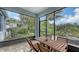 View of a screened patio with a rustic wood dining table and serene landscaping at 5068 Inshore Landing Dr, Apollo Beach, FL 33572