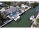 Aerial view of a waterfront home, showcasing its screened-in pool, private dock, and boat lift on a canal at 552 Juan Anasco Drive, Longboat Key, FL 34228