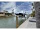 Private boat dock with lift on the canal, surrounded by lush tropical landscaping at 552 Juan Anasco Drive, Longboat Key, FL 34228