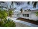 Charming single-story home featuring a white brick exterior, mature landscaping, and a welcoming entryway at 552 Juan Anasco Drive, Longboat Key, FL 34228