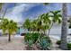 Charming home featuring a teal front door, tropical landscaping, gravel yard, and inviting curb appeal at 552 Juan Anasco Drive, Longboat Key, FL 34228