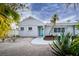 Charming home featuring a teal front door, painted brick, tropical landscaping, and welcoming walkway at 552 Juan Anasco Drive, Longboat Key, FL 34228