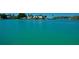 Scenic waterfront view with turquoise water, lush greenery, and beautiful homes in the distance at 552 Juan Anasco Drive, Longboat Key, FL 34228