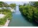 Scenic view of a tranquil canal with lush mangroves, boats docked, and waterfront properties, offering serene living at 552 Juan Anasco Drive, Longboat Key, FL 34228